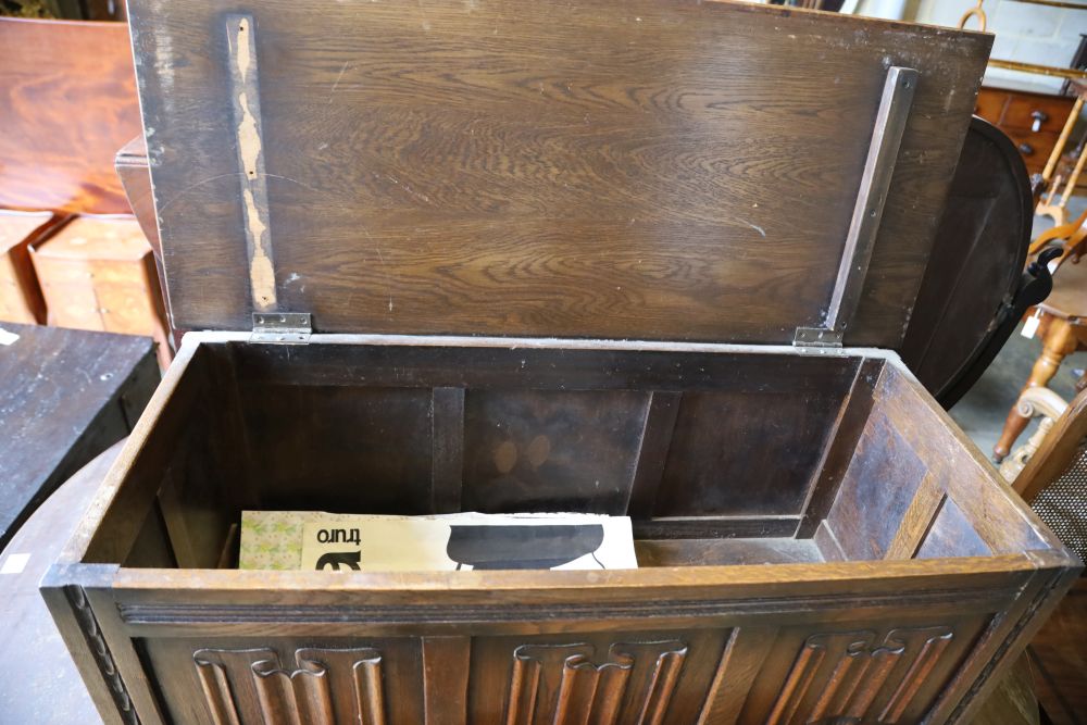 A reproduction oak linenfold coffer, width 104cm depth 45cm height 51cm